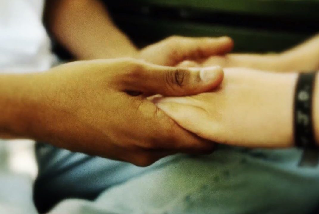 Händer som håller i varandra i närbild.