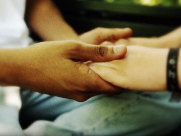 Händer som håller i varandra i närbild.